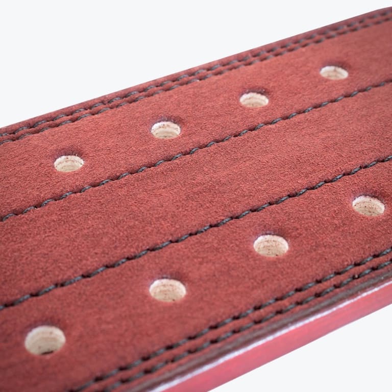 Close-up view of a reddish-brown suede weightlifting belt featuring double-prong holes and black stitching.