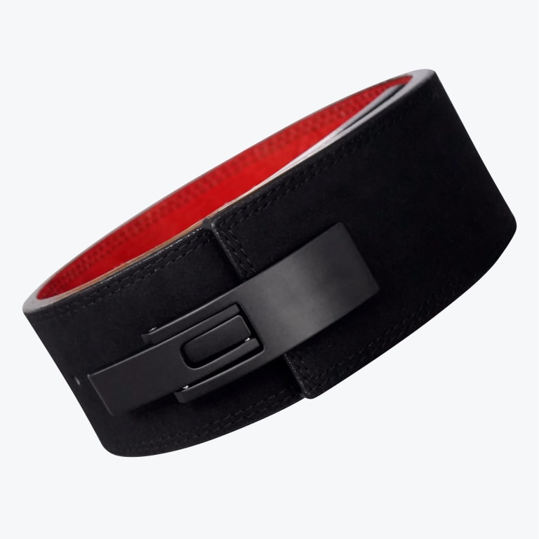 A black suede lever weightlifting belt with a red interior lining and a matte black metal lever buckle, shown at an angle against a white background.
