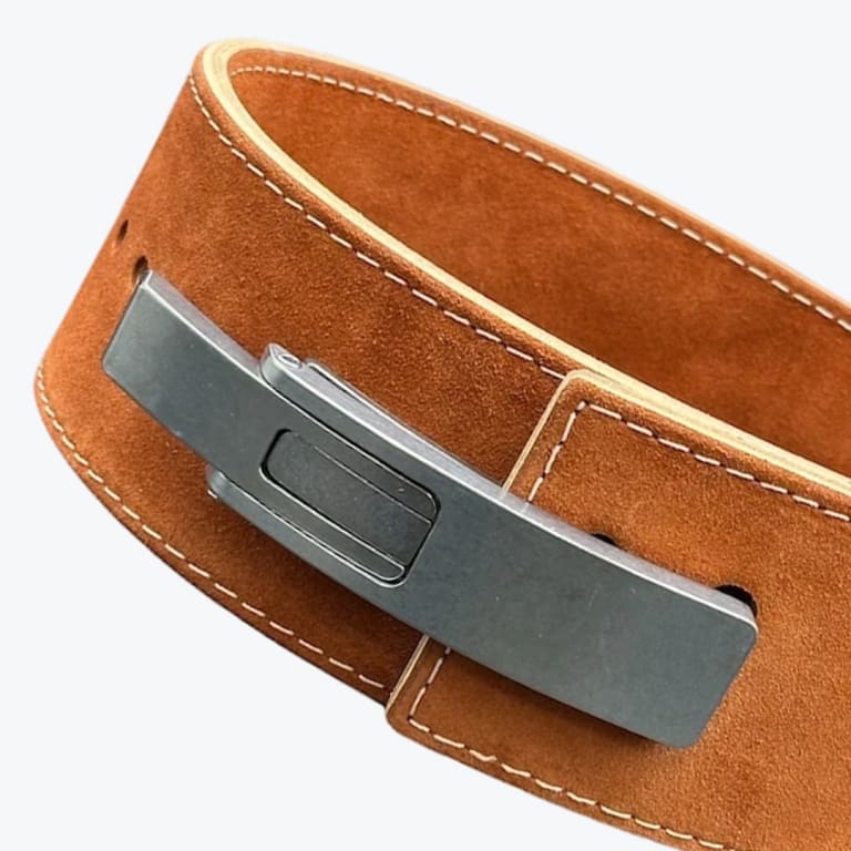 Close-up of a brown suede powerlifting belt with a matte grey metal lever buckle against a white background.