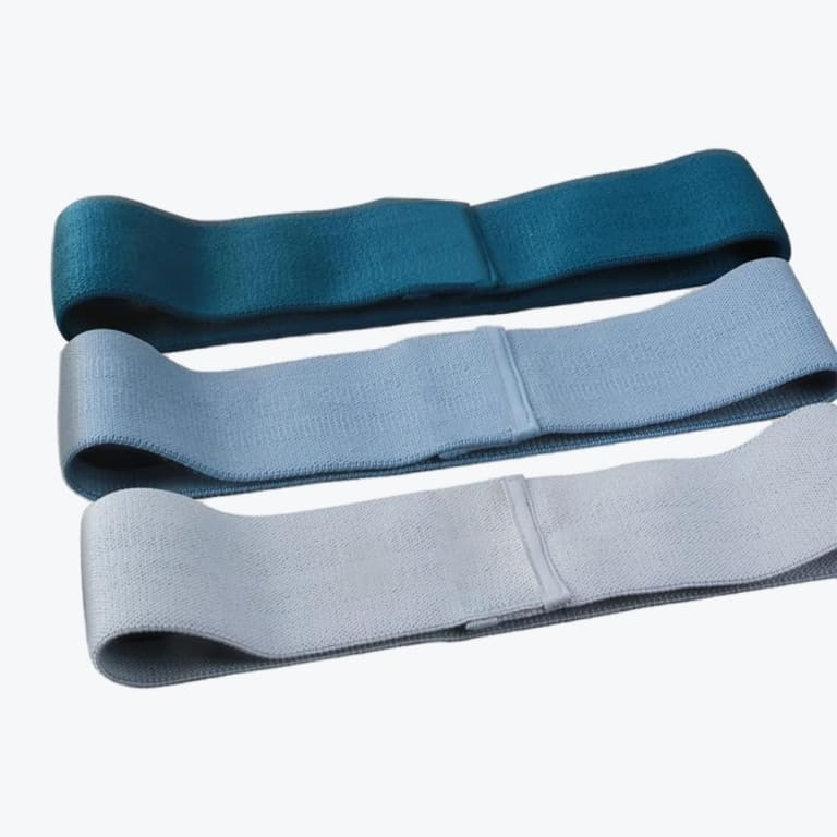 Three fabric resistance bands in dark teal, medium blue, and light grey-blue stacked horizontally against a white background.