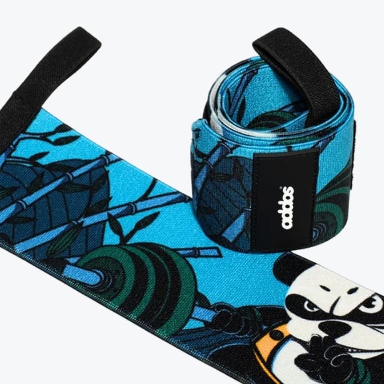 A pair of blue athletic wrist wraps featuring a cartoon panda lifting a barbell and bamboo graphics, with one rolled up showing the Addos brand patch.