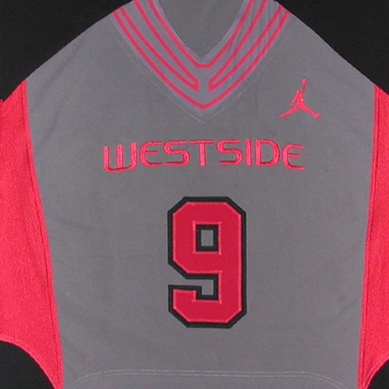 A grey basketball jersey with red side panels, featuring the red embroidered text WESTSIDE and the number 9 outlined in black, with a red Jordan logo on the chest.