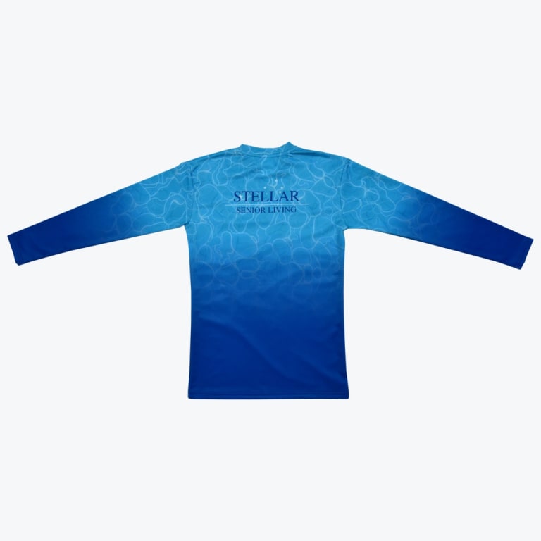 A long-sleeved shirt with a blue gradient and water-ripple pattern, featuring the Stellar Senior Living logo on the upper back.