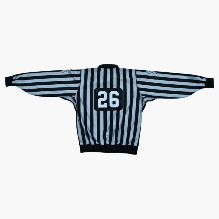 The back of a black and white striped long-sleeve referee jersey with the number 26 printed on the back.