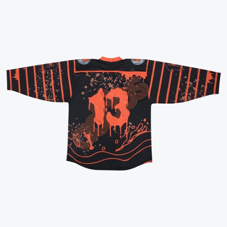 Back view of a black streetwear jersey with a dripping orange number 13 and graffiti-style graphics, featuring striped sleeves with paint splatters.