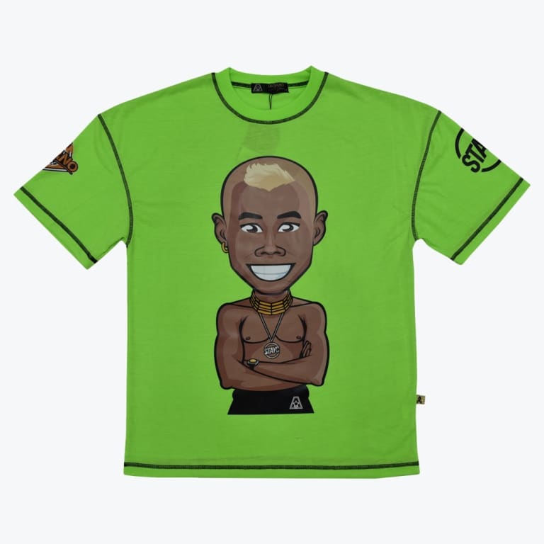 A bright lime green t-shirt with black contrast stitching, featuring a central cartoon illustration of a smiling, shirtless Black man with a blonde mohawk and gold neck rings.