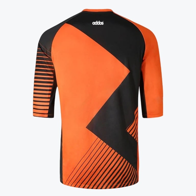 Back view of an orange and black athletic shirt with geometric patterns, striped sleeves, and a small white logo on the upper back.