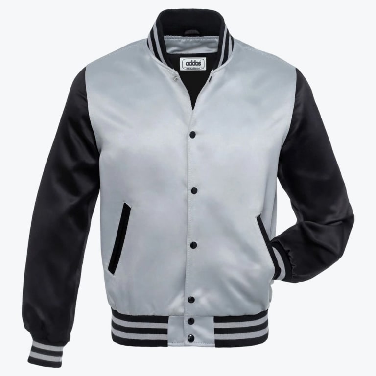 A silver and black satin varsity jacket with snap buttons and striped ribbed trim, displayed against a white background.
