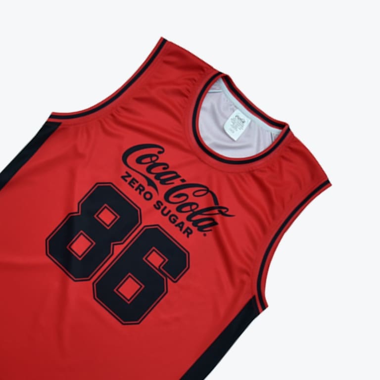 A red basketball jersey featuring the black Coca-Cola Zero Sugar logo and the number 86.