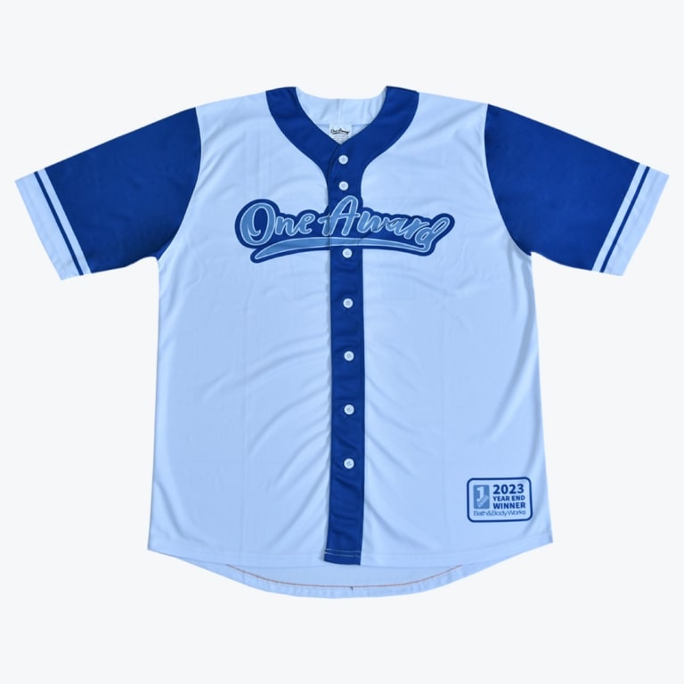 A light blue and royal blue baseball jersey with One Award on the chest and a 2023 Year End Winner Bath Body Works patch on the bottom right.