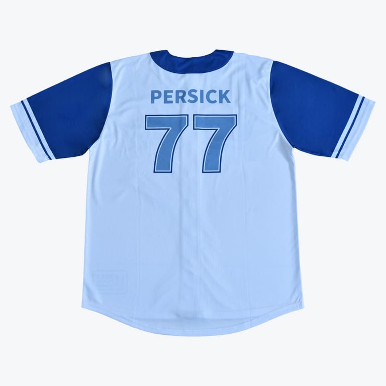 The back of a light blue baseball jersey with dark blue sleeves, featuring the name PERSICK and the number 77 printed in blue on the back.