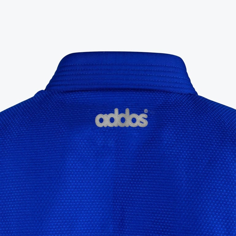 Close-up of the upper back of a blue martial arts gi showing the stitched collar and an embroidered white brand logo.
