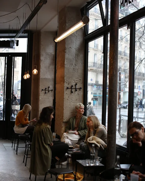 Vue du café Le Partisan, avec ses grandes baies vitrées et sa décoration industrielle, où l'on peut déguster un café de spécialité