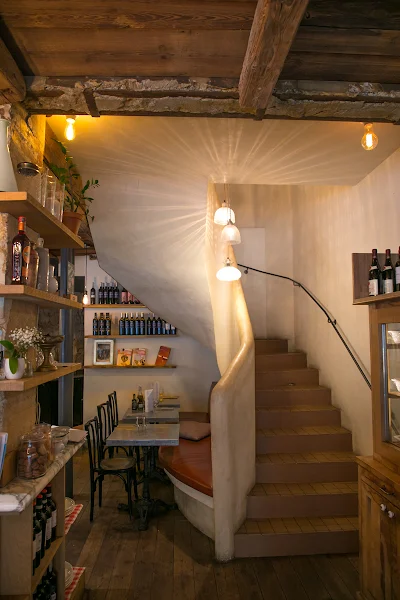 Intérieur de Marcella, restaurant italien à Paris 8 qui montre des tables et une banquette en cuir adossée à un élégant escalier en chaux blanche
