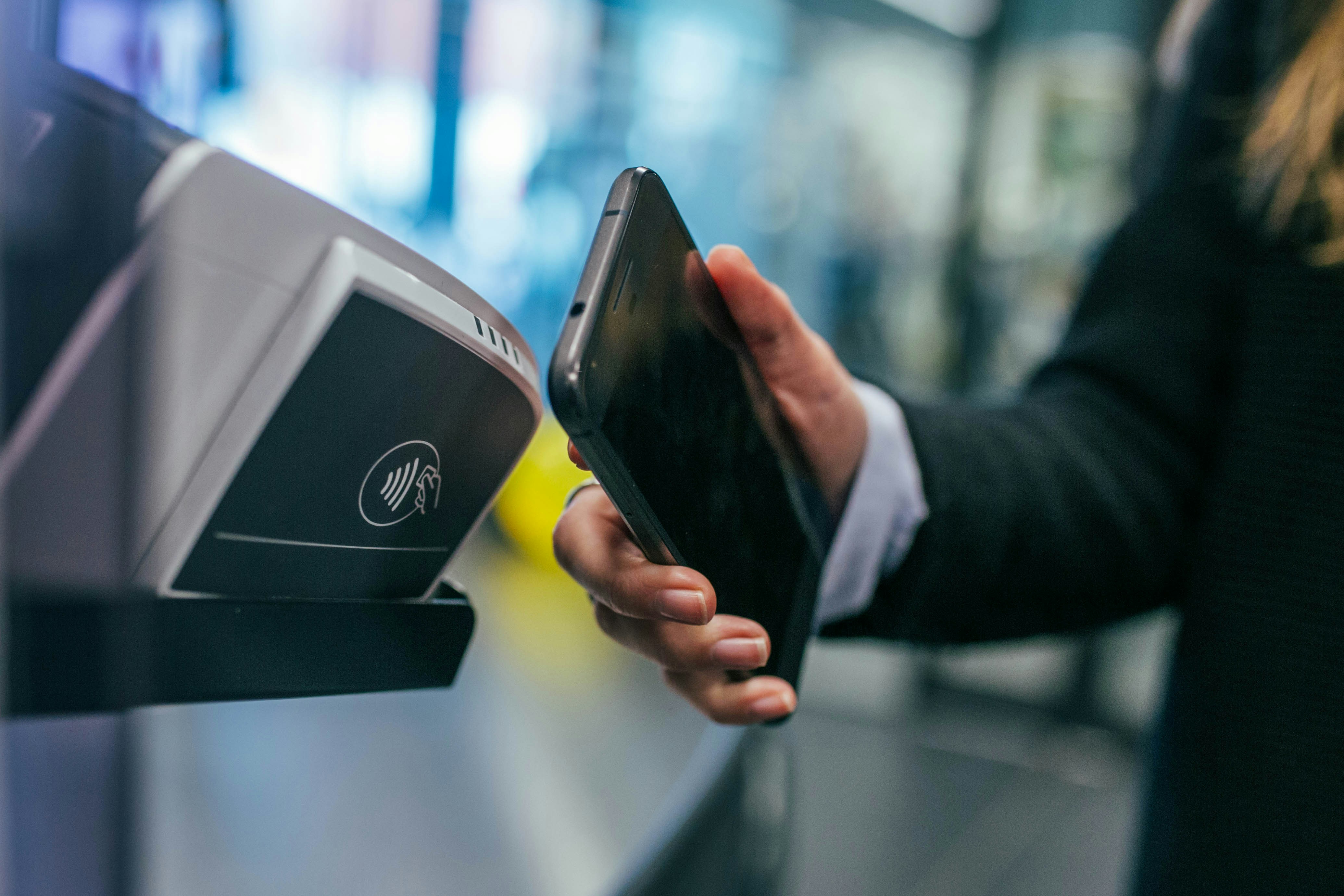 A woman making a contactless payment with a smartphone.