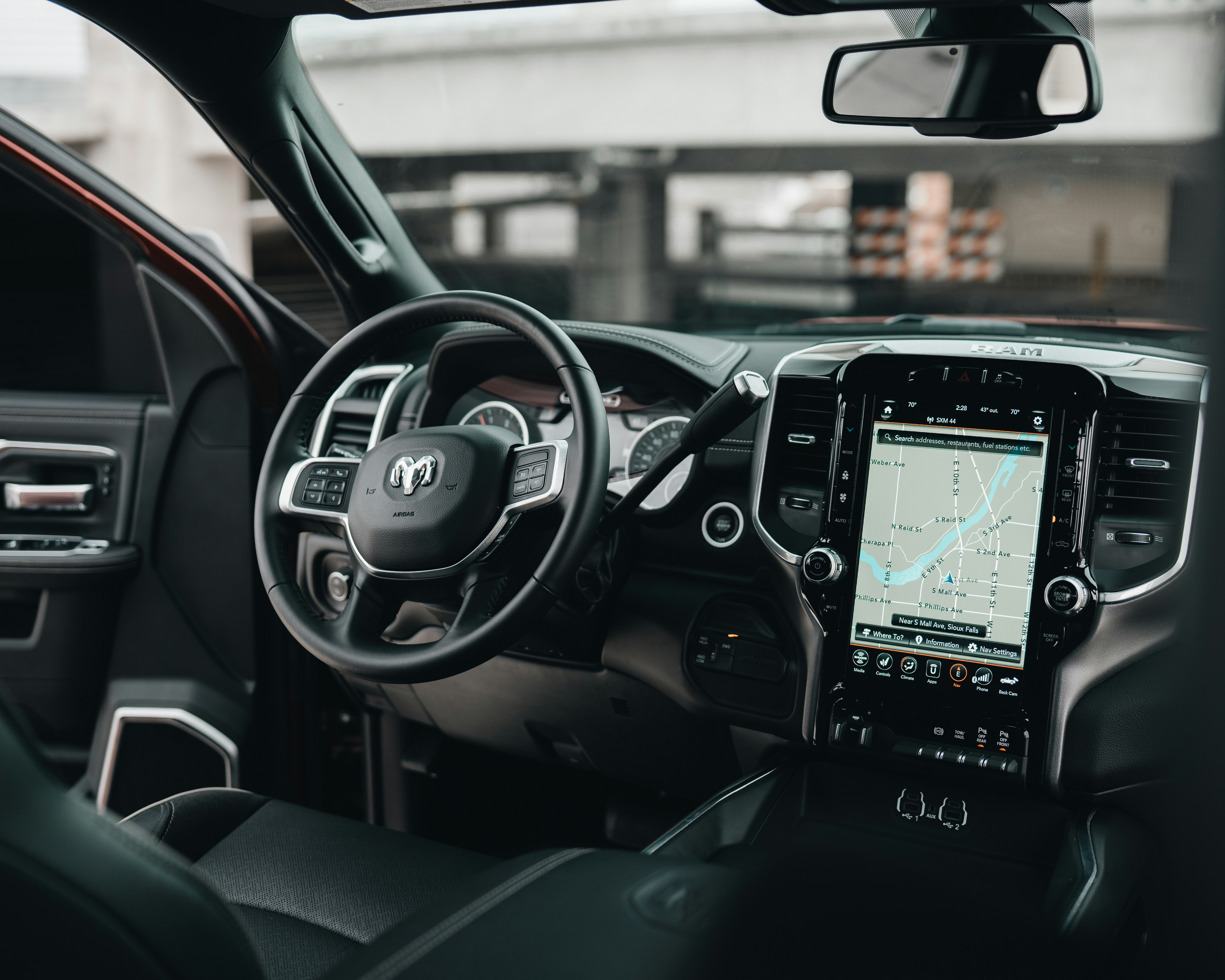 large navigation screen next to steering wheel in dodge vehicle black interior