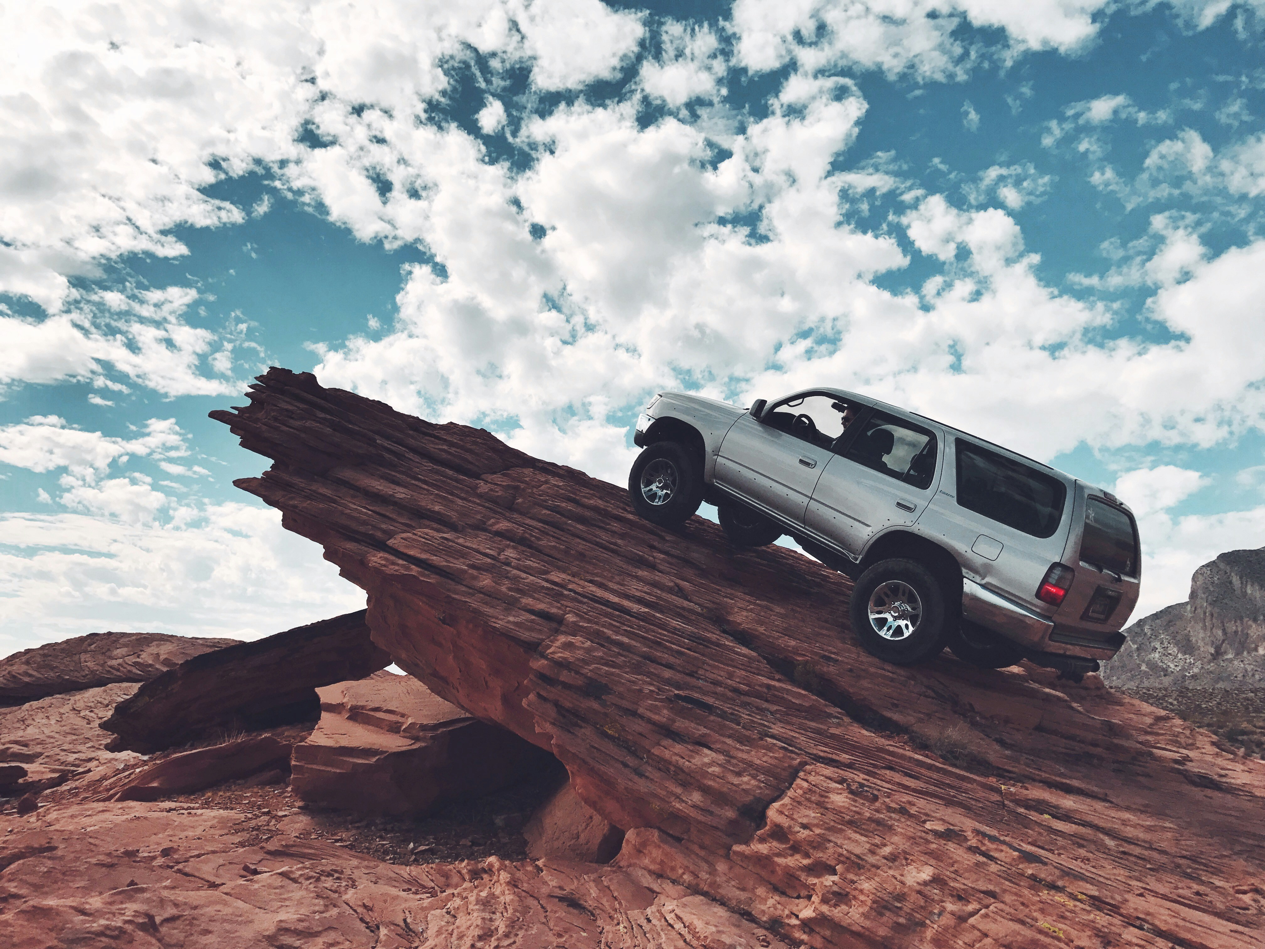 silver SUV on dramatic red cliff rock
