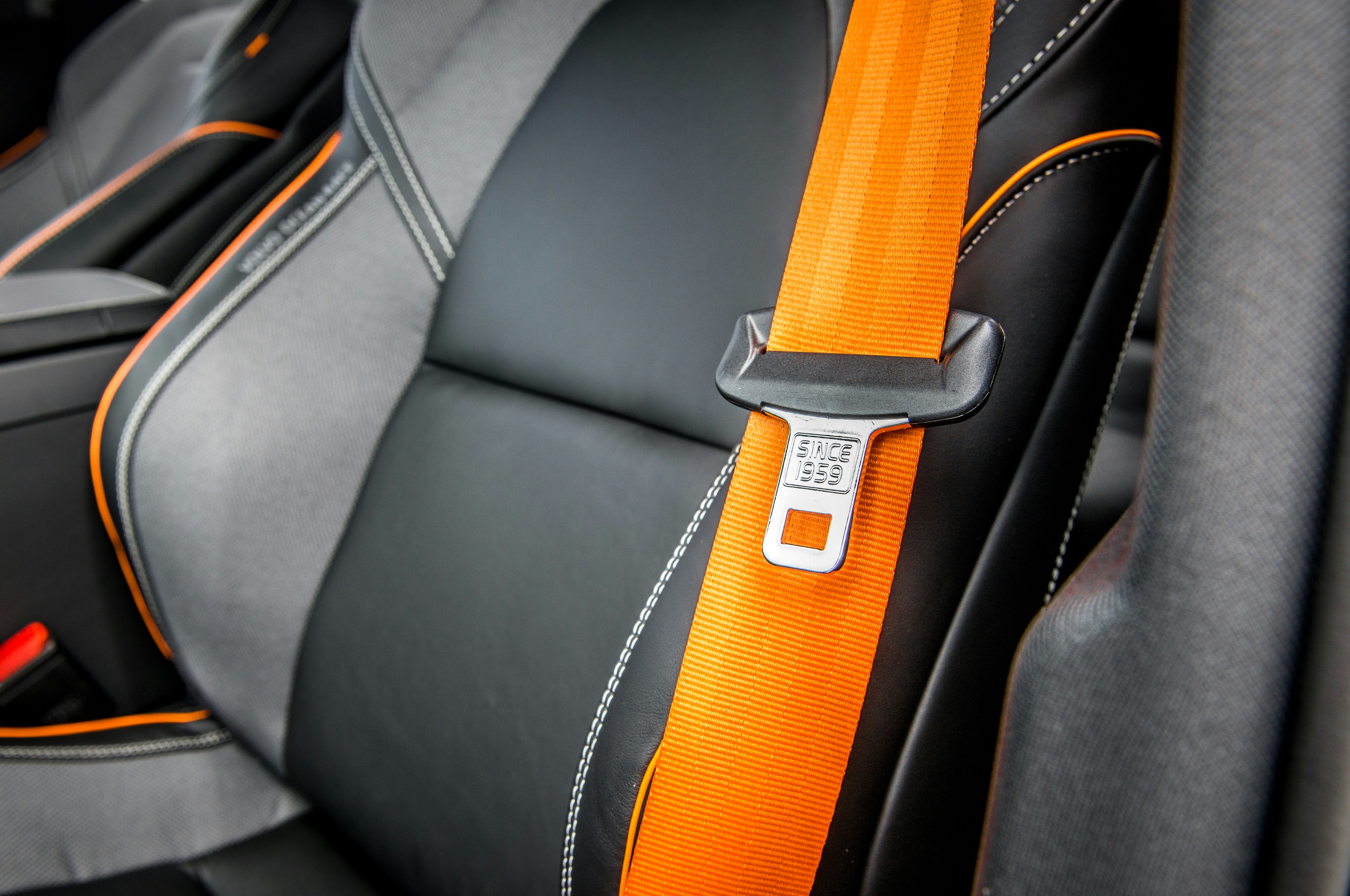 orange seat belt loose on black seat