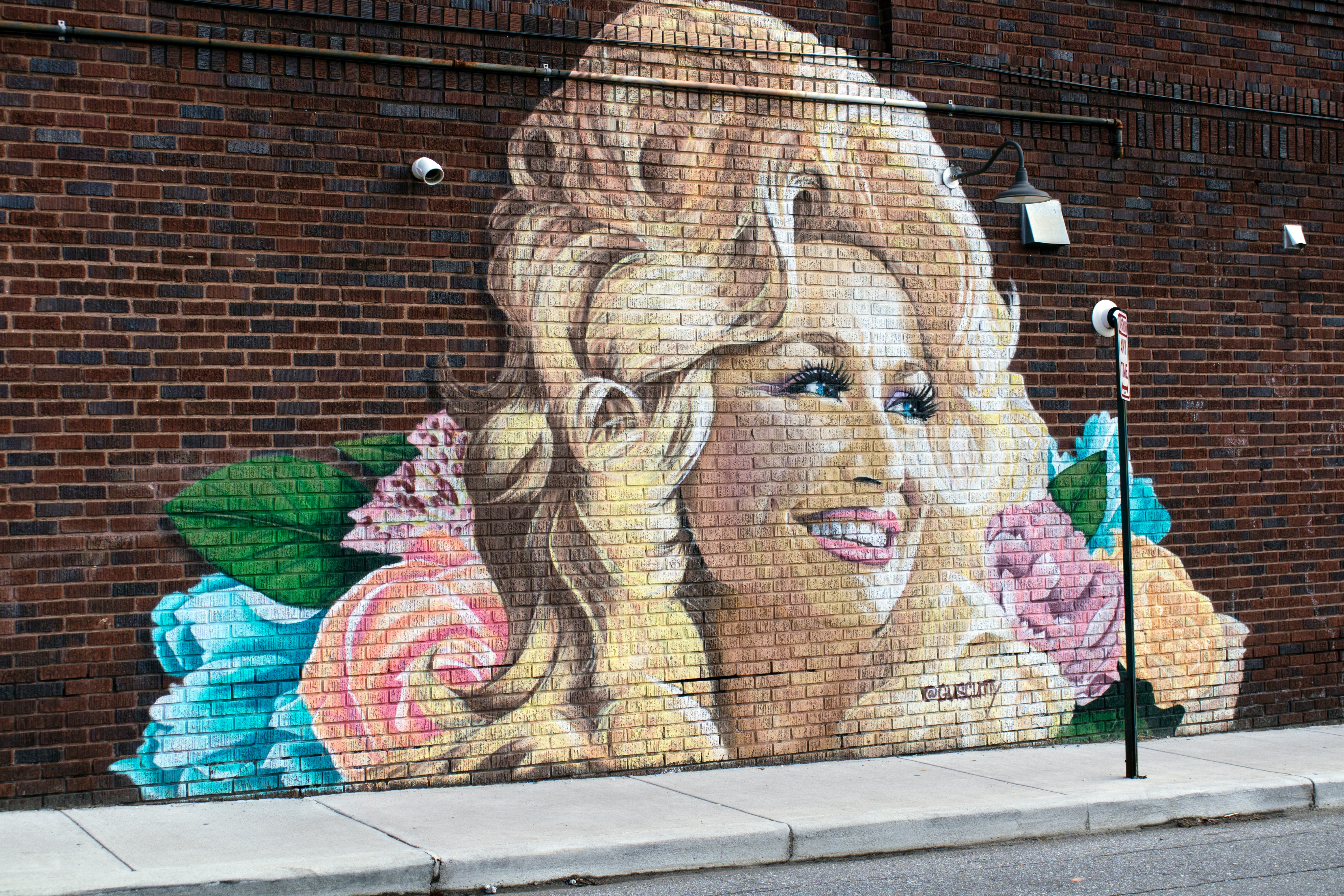 mural of Dolly Parton on a brick wall