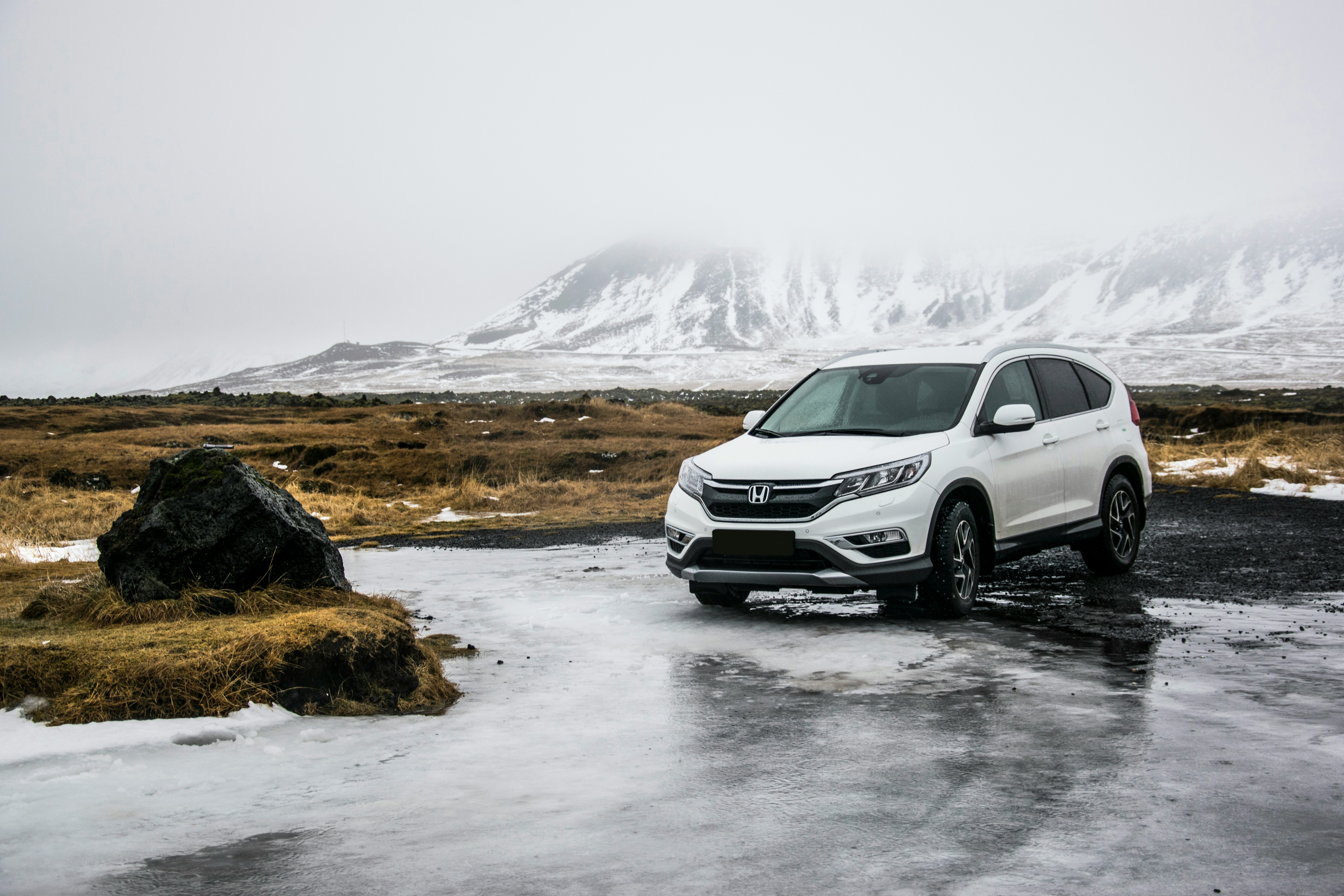 white SUV on ice in front of mountains