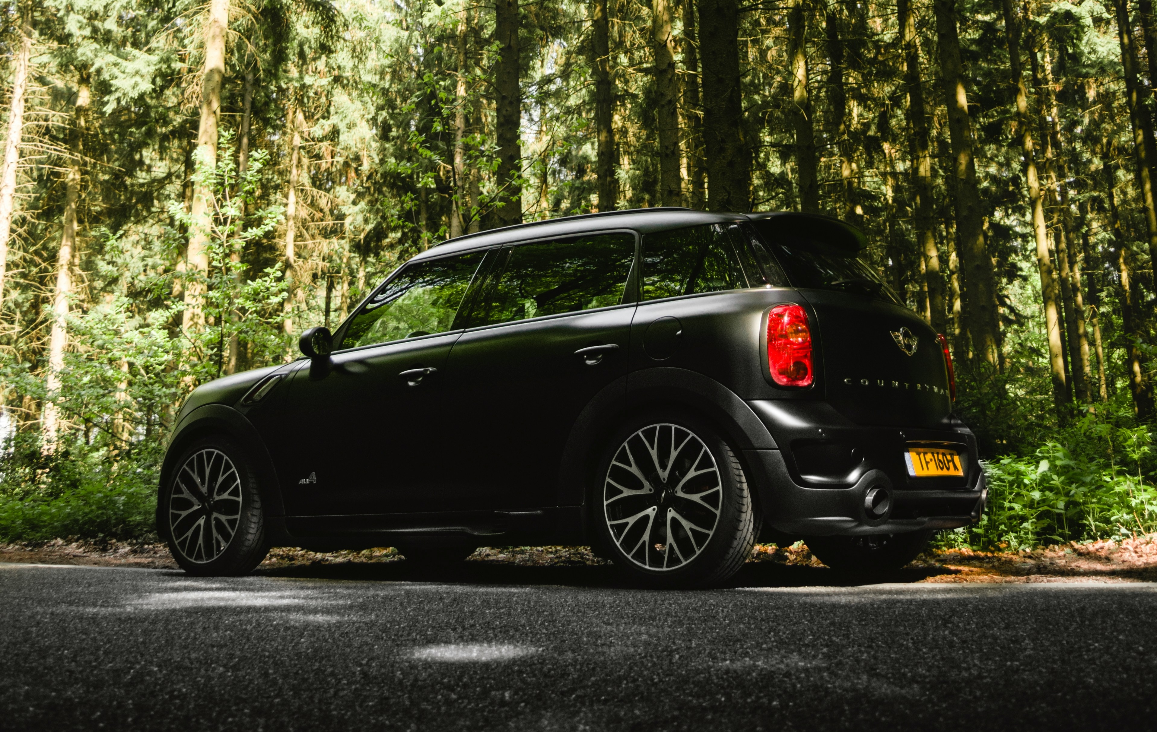 black crossback parked on the side of the road in the woods