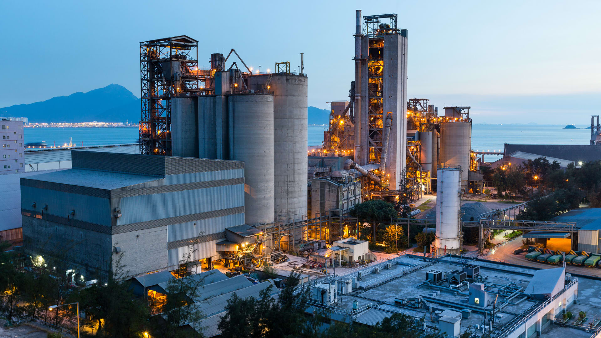 Industrial processing plant with silos and towers at dusk
