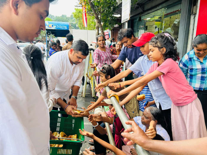 Donating Seeni Sambol Buns to People watching Kandy Dalada Perahara