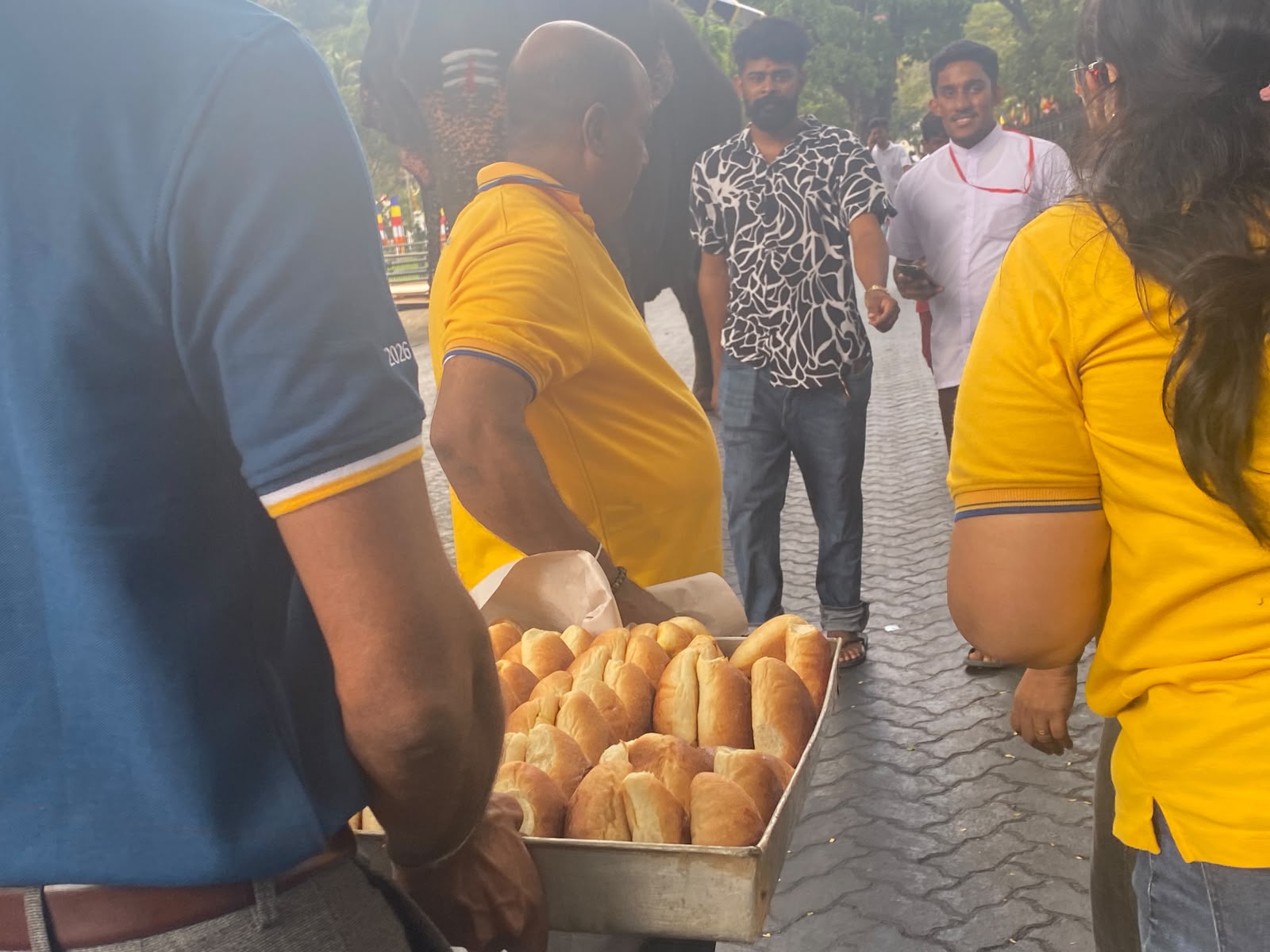 Donating Seeni Sambol Buns to People watching Kandy Dalada Perahara photo 2
