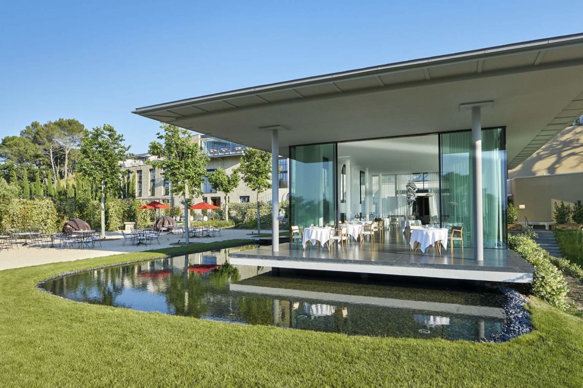 Le pavillon de verre du restaurant Louison de Villa La Coste posé au bord d'un bassin
