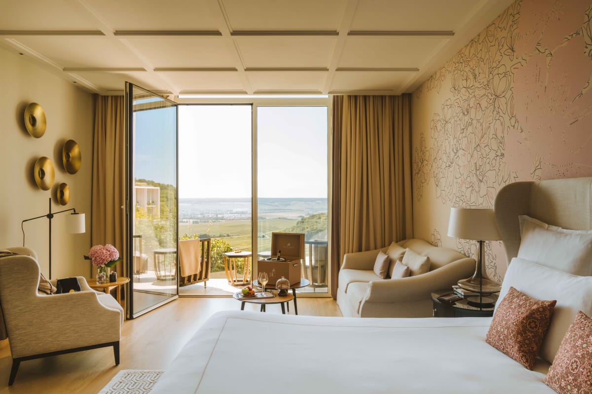 Junior suite du Royal Champagne Hotel & Spa ouverte sur une terrasse avec vue sur les vignobles champenois
