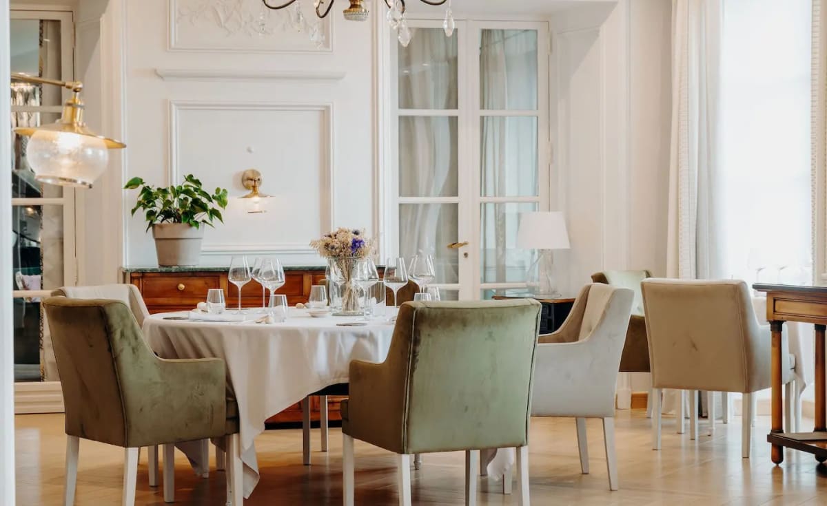 La salle lumineuse du restaurant Le M au Domaine de Rochebois, tables dressées et moulures