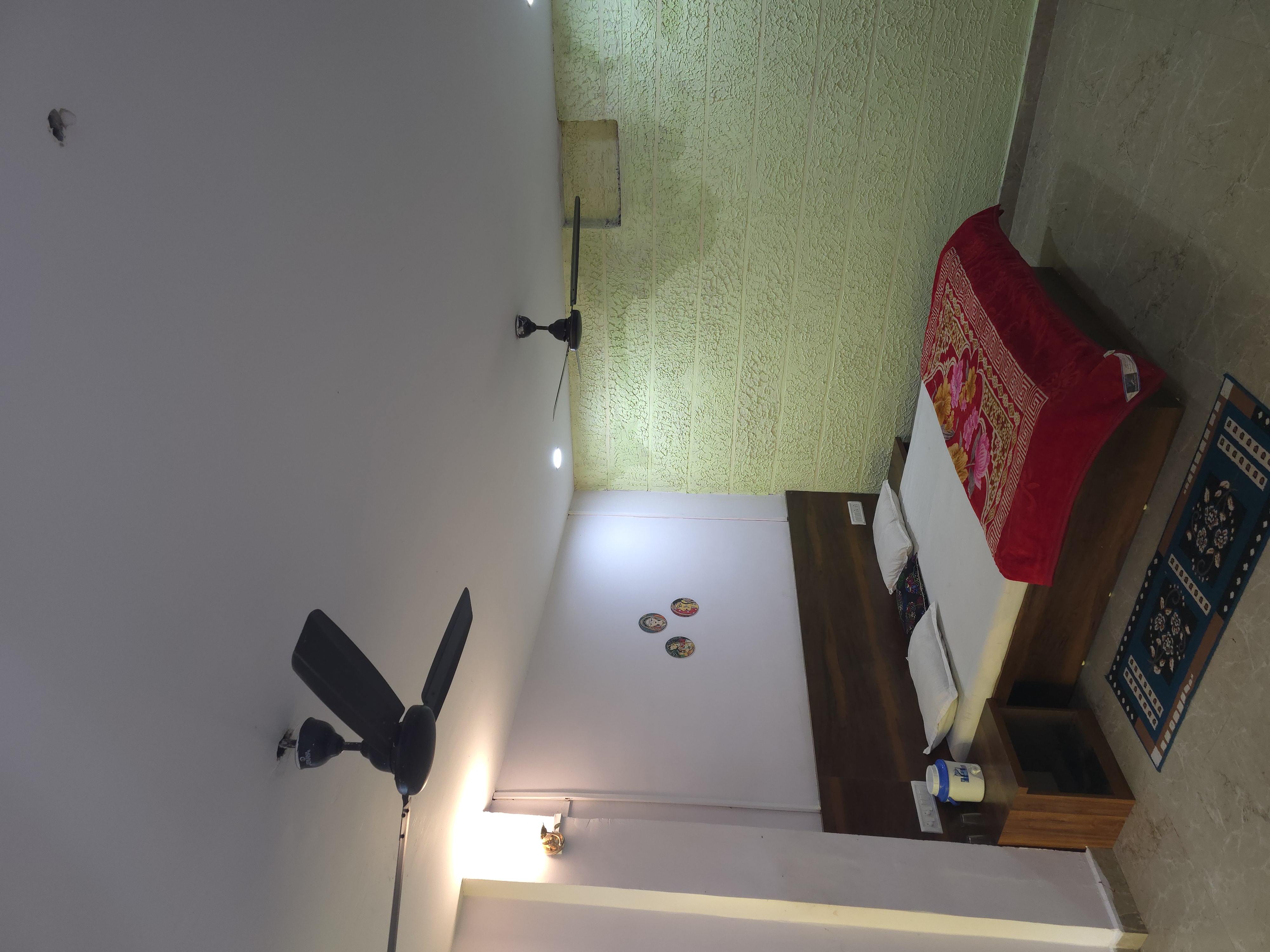 Double-bed room with green textured wall at Mahaveer Home Stay, Pachmarhi
