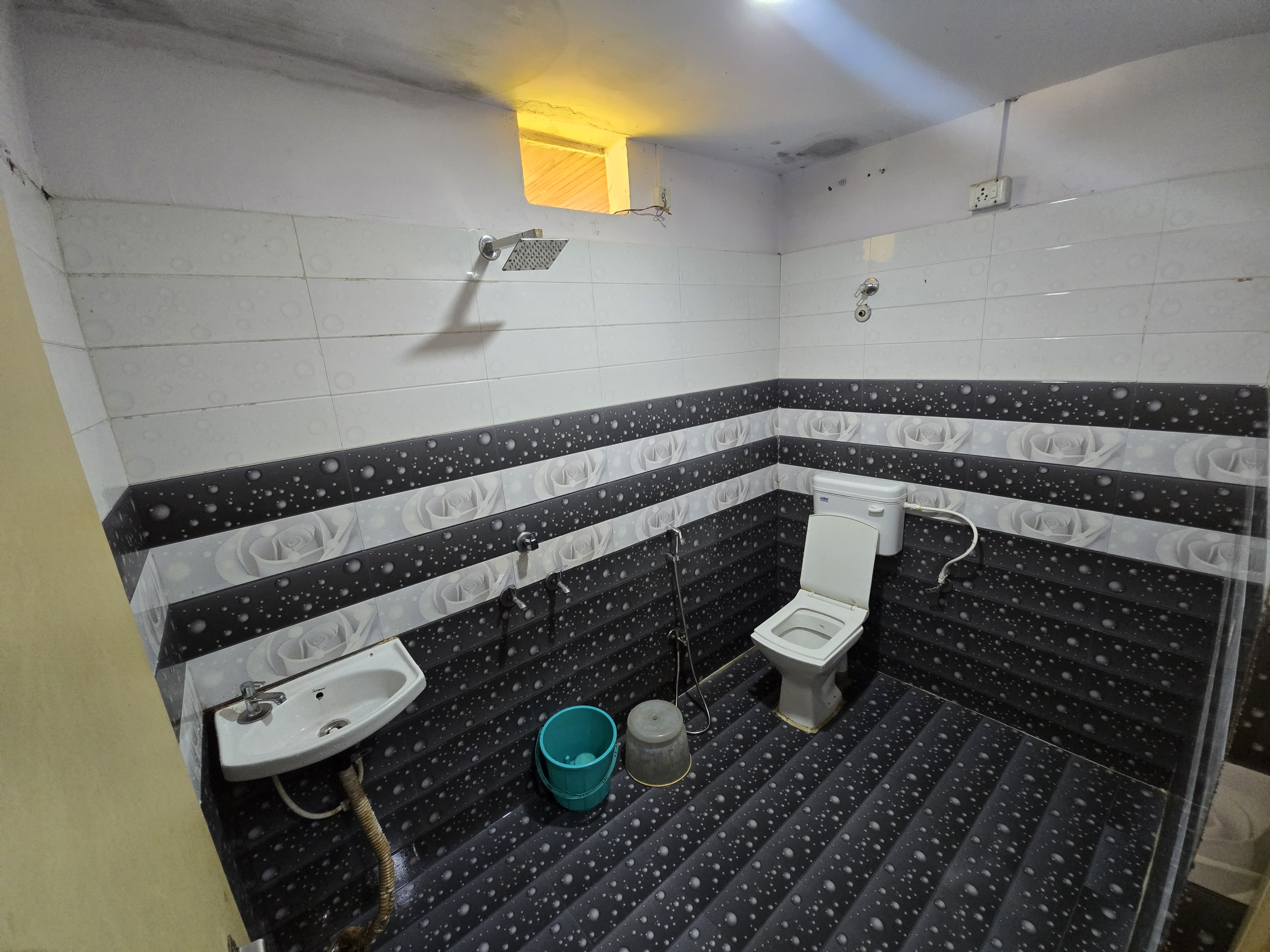 Tiled bathroom with shower and 24-hour hot water at Mahaveer Home Stay