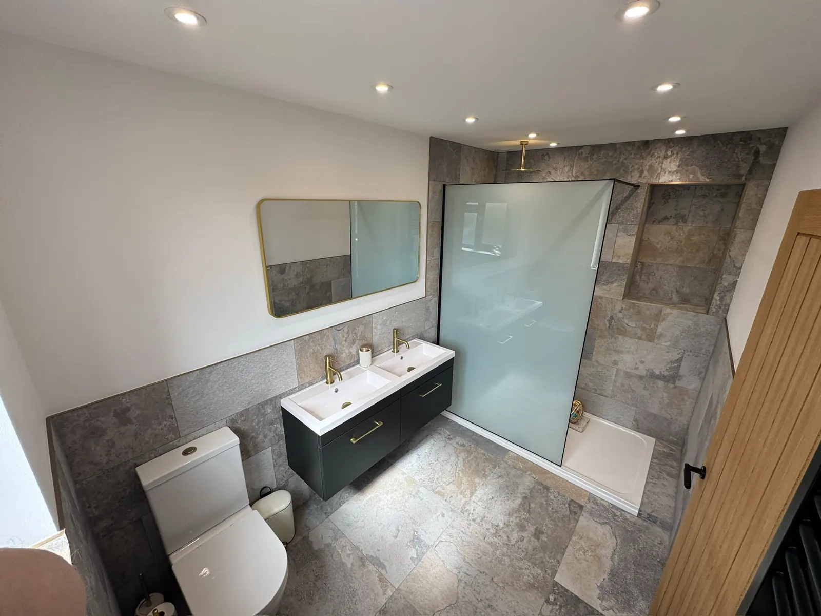 Slate-effect walk-in shower with a double vanity and brass taps