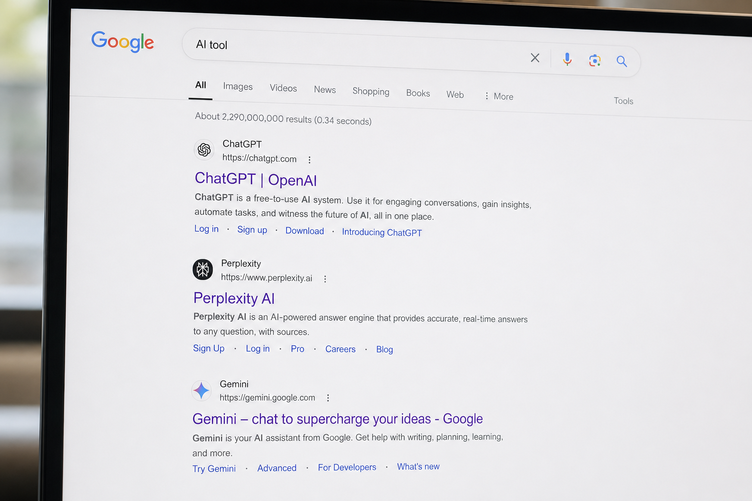 Close-up of a laptop screen showing Google search results for 'AI tool' listing ChatGPT, Perplexity AI, and Gemini.