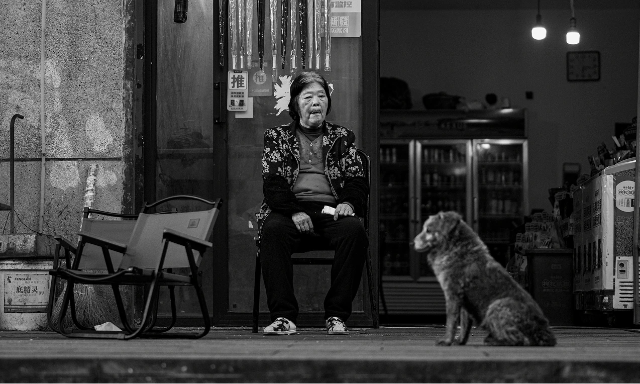 坐在店门口的老人和狗