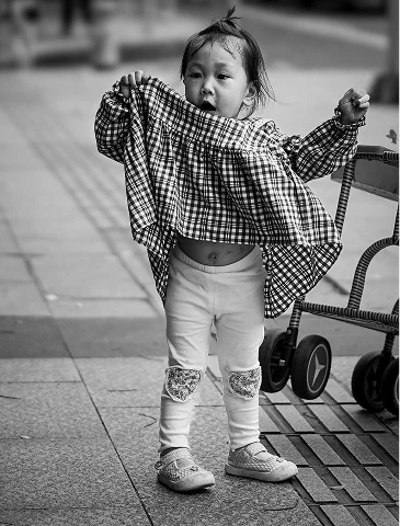 举起格子上衣的小女孩