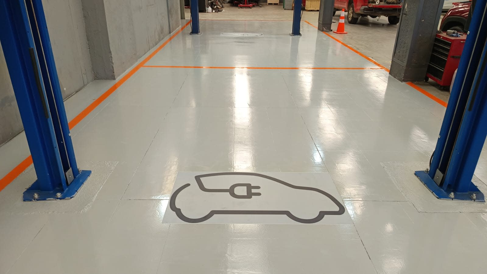 Piso epóxico gris con demarcación en taller Ford El Rodeo Santiago