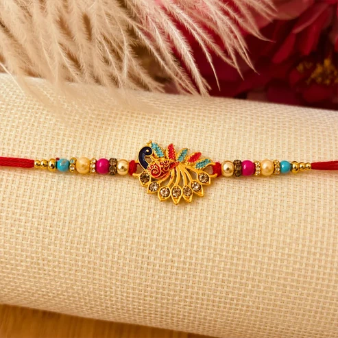 Peacock Rakhi – Elegant Stone Detailing with Red Thread