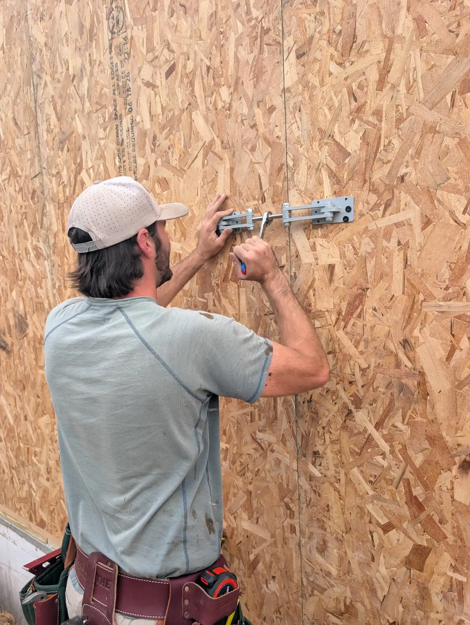 Ratcheting a wall bracket to pull SIP wall panels tight