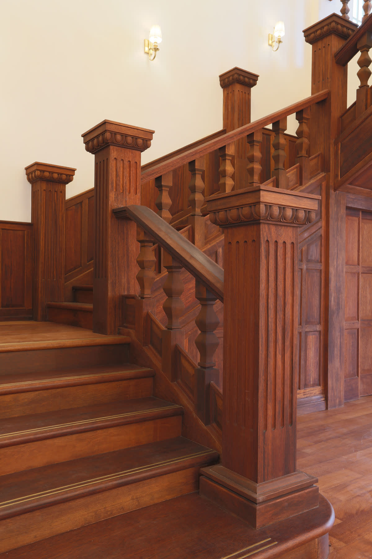 Restored timber staircase and carved newel post at Seri Negara, showcasing heritage conservation architectural detailing.