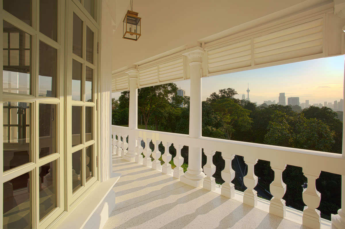 Balcony of restored Seri Negara heritage building overlooking Kuala Lumpur skyline.