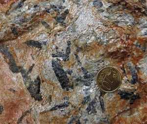 05. Particolare del micascisto eclogitico. Visibili le lamelle di mica bianca, il quarzo e grossi cristalli blu scuro di glaucofane, un anfibolo di grande profondità e bassa temperatura.