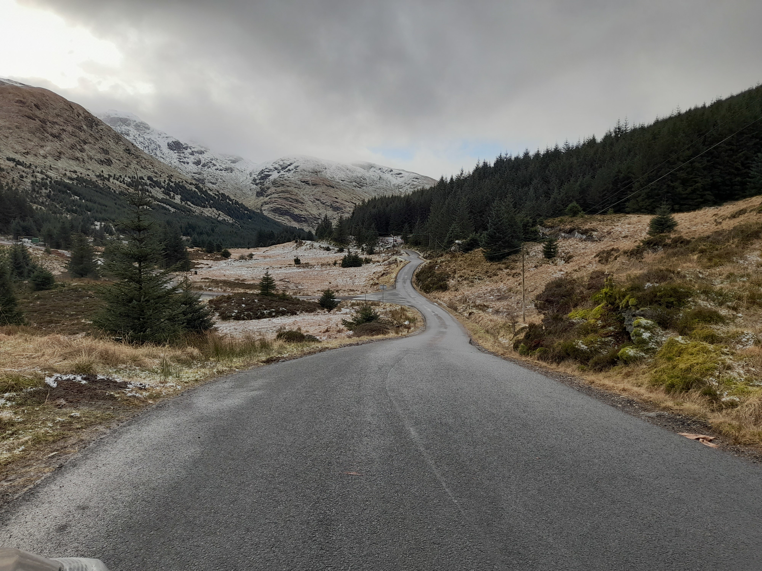 A road winds up into the rugged mountains of Scotland