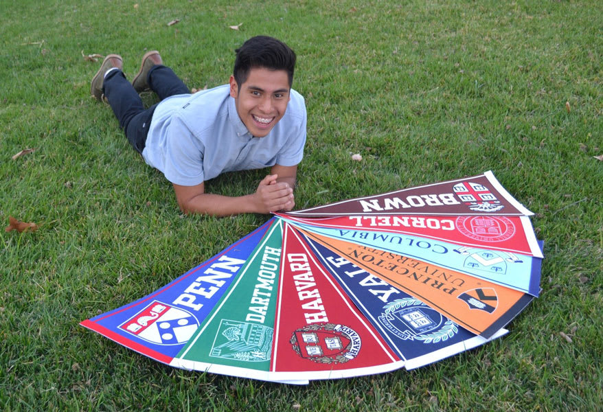 Quetzalmama scholar on grass next to all their accepted school's banners.
