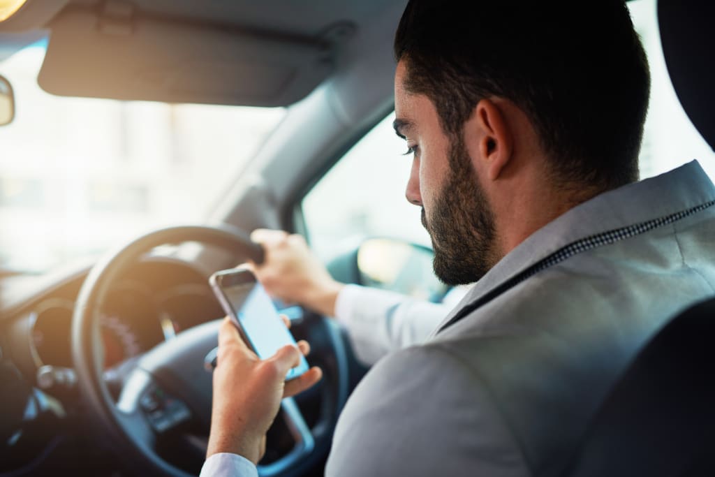 A man using his mobile phone while driving