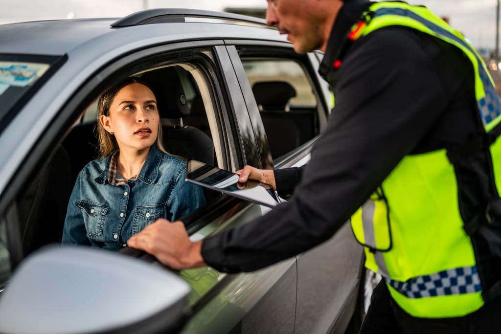 Police officer ticketing young woman driver