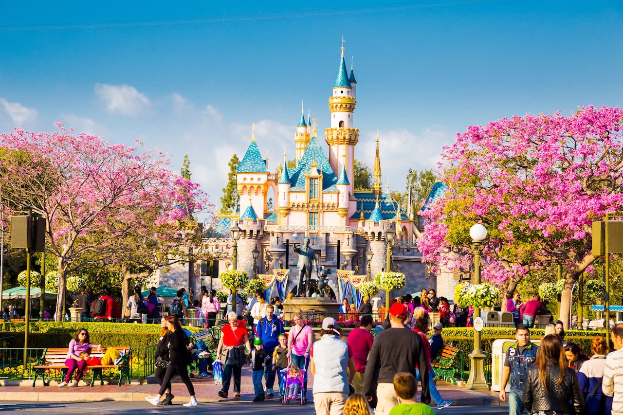 65584359_DXDDG3_Disneyland_Main_Street_crowded_with_guests_and_a_tram_car_in_the_road_leading_to