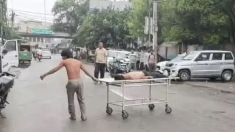 करनाल के घरौंडा में सड़क हादसे में जान गंवाने वाले दोस्त के शव को स्ट्रेचर समेत सड़क की तरफ खींचता हुआ बदहवास युवक।