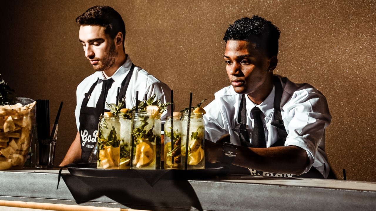 two bartenders serving drinks